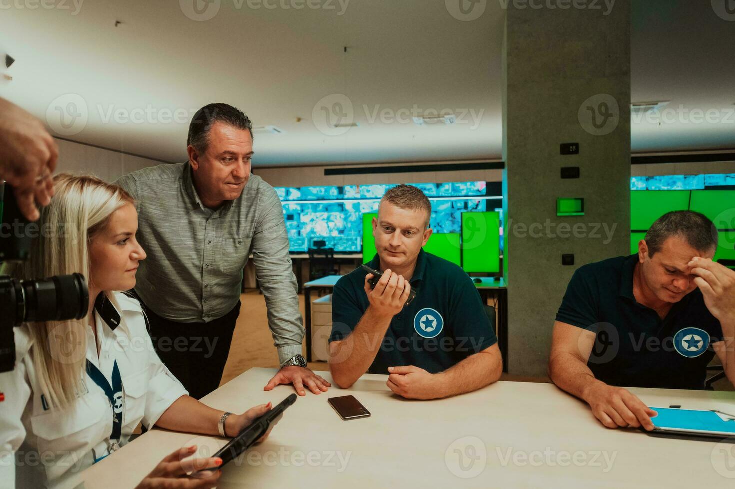 Group of security guards sitting and having briefing In the system control room They're working in security data center surrounded by multiple Screens photo