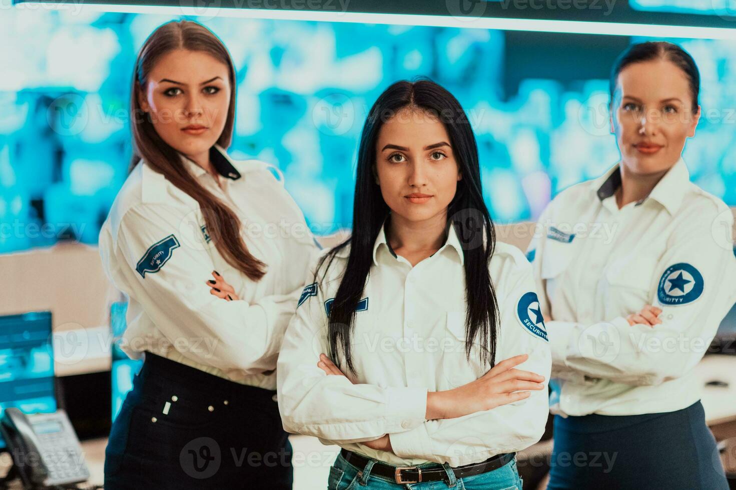 group portrait of female security operator while working in a data system control room offices Technical Operator Working at workstation with multiple displays, security guard working on multiple mon photo