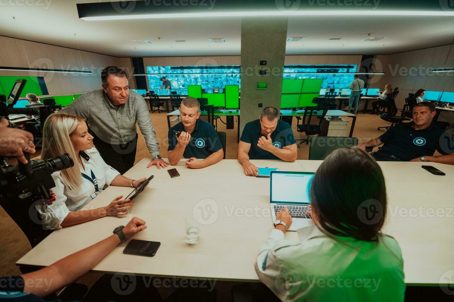 Group of security guards sitting and having briefing In the system control room They're working in security data center surrounded by multiple Screens photo