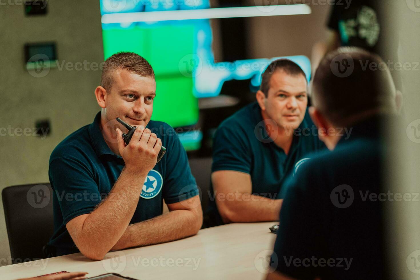 Group of security guards sitting and having briefing In the system control room They're working in security data center surrounded by multiple Screens photo