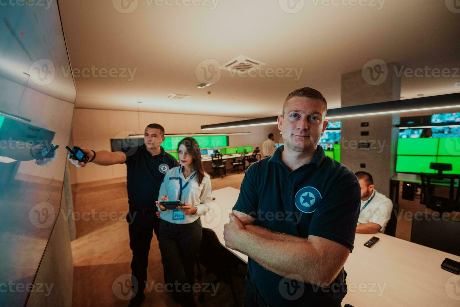 Group of Security data center operators working in a CCTV monitoring room looking on multiple monitors Officers Monitoring Multiple Screens for Suspicious Activities Team working on the System Contr photo