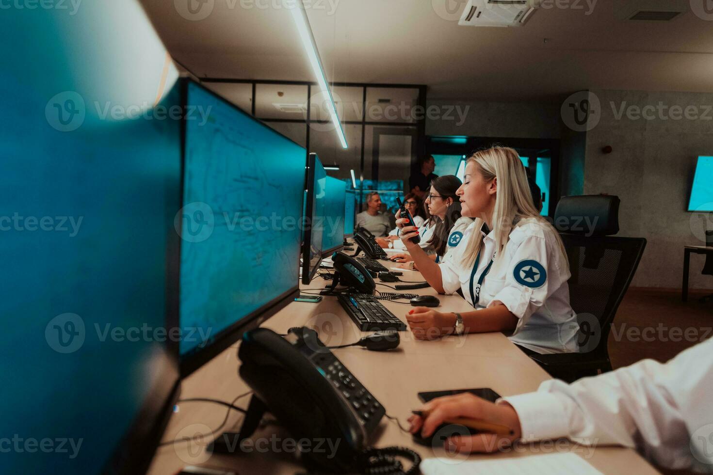 Group of female security operators working in a data system control room Technical Operators Working at workstation with multiple displays, security guards working on multiple monitors in surveillan photo