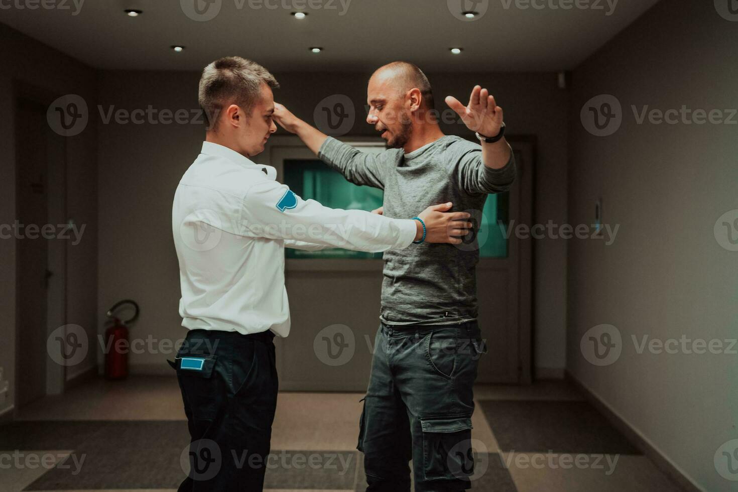 Security guard making body searching procedure on man for finding hidden objects before entering in treasury department photo