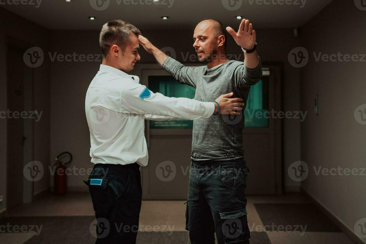 Security guard making body searching procedure on man for finding hidden objects before entering in treasury department photo