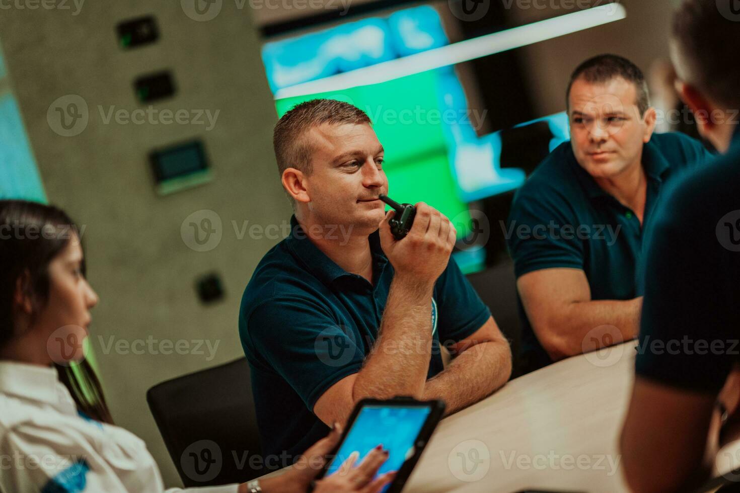 Group of security guards sitting and having briefing In the system control room They're working in security data center surrounded by multiple Screens photo