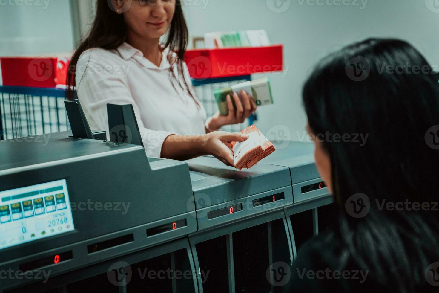 Bank employees using money counting machine while sorting and counting paper banknotes inside bank vault. Large amounts of money in the bank photo