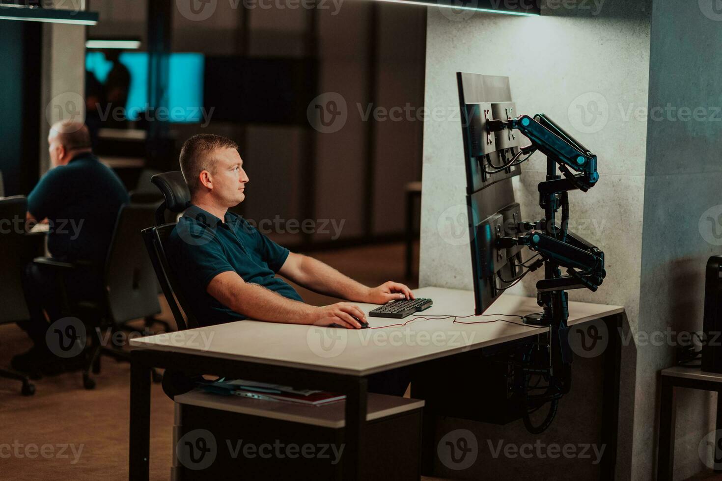 Male security operator working in a data system control room offices Technical Operator Working at workstation with multiple displays, security guard working on multiple monitors Male computer opera photo