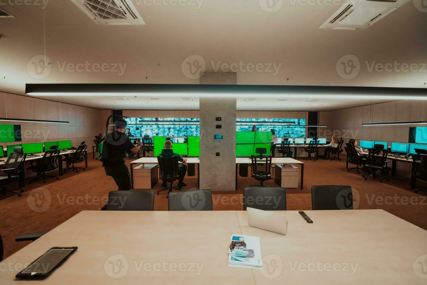 Professional videographer with gimball video slr recording video of Security data center operators while working in a CCTV monitoring room looking on multiple monitors Team working on the System Con photo