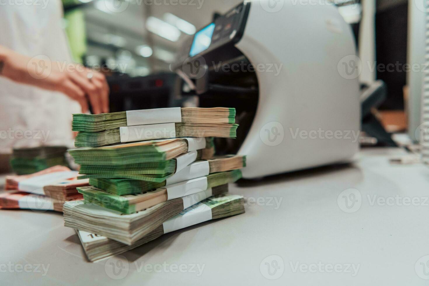 Bank employees using money counting machine while sorting and counting paper banknotes inside bank vault. Large amounts of money in the bank photo