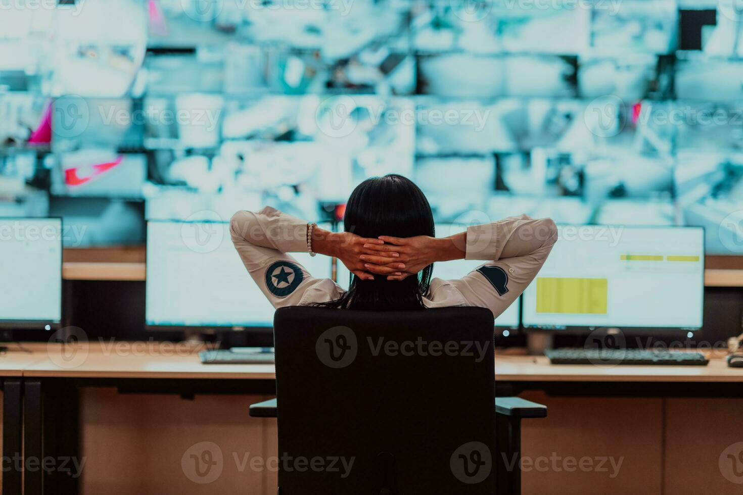 Female security operator working in a data system control room offices Technical Operator Working at workstation with multiple displays, security guard working on multiple monitors photo