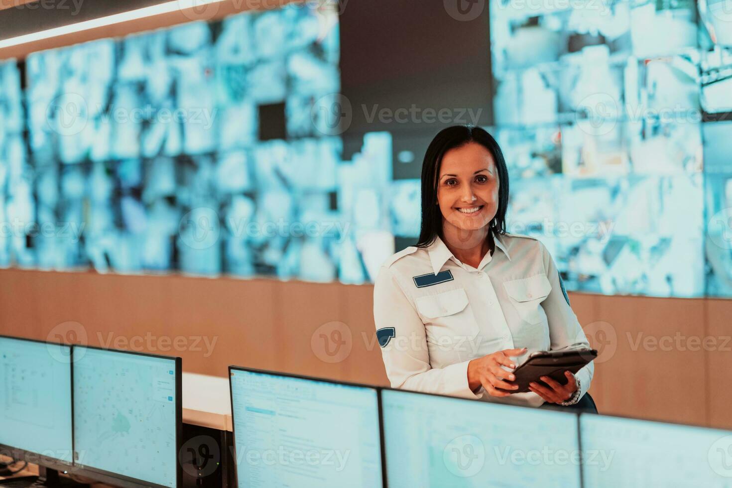 Portrait of female security operator while working in a data system control room offices Technical Operator Working at workstation with multiple displays, security guard working on multiple monitors photo