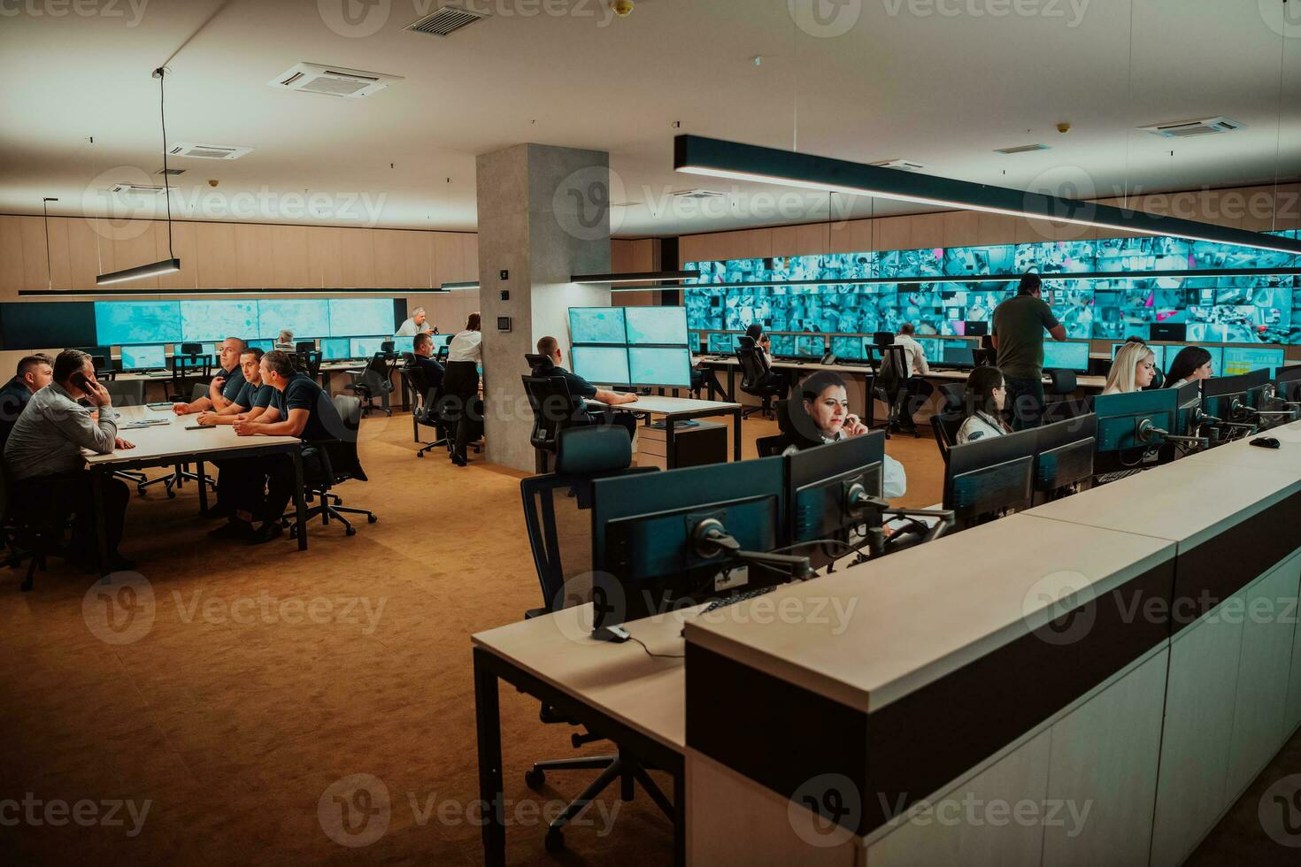Group of Security data center operators working in a CCTV monitoring room looking on multiple monitors Officers Monitoring Multiple Screens for Suspicious Activities Team working on the System Contr photo