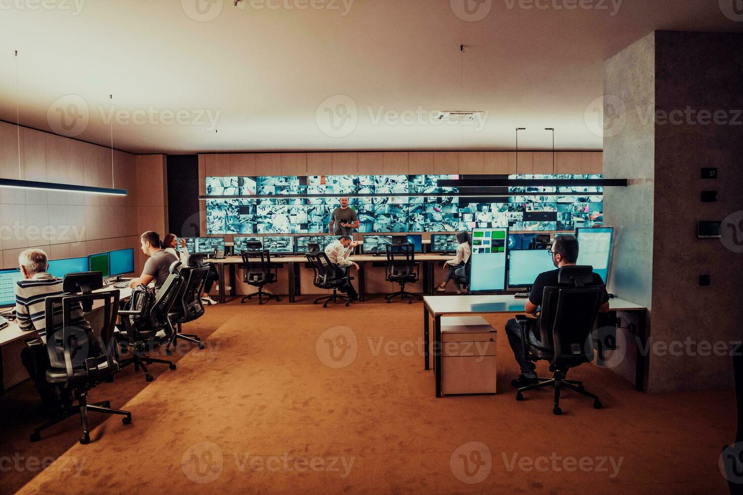 Group of Security data center operators working in a CCTV monitoring room looking on multiple monitors Officers Monitoring Multiple Screens for Suspicious Activities Team working on the System Contr photo