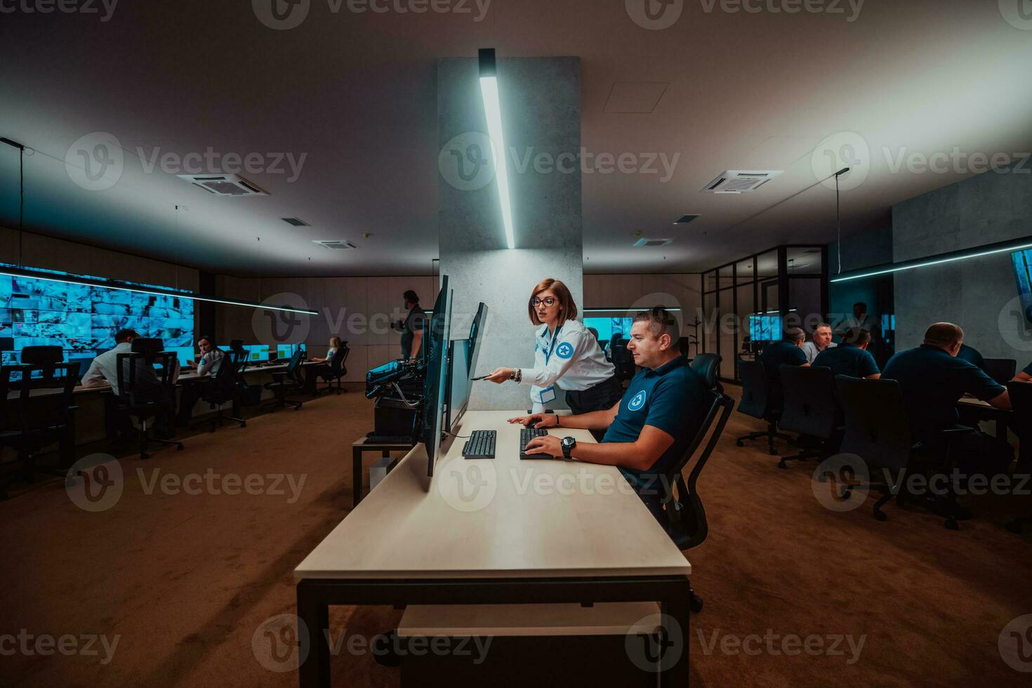 Group of Security data center operators working in a CCTV monitoring room looking on multiple monitors Officers Monitoring Multiple Screens for Suspicious Activities Team working on the System Contr photo