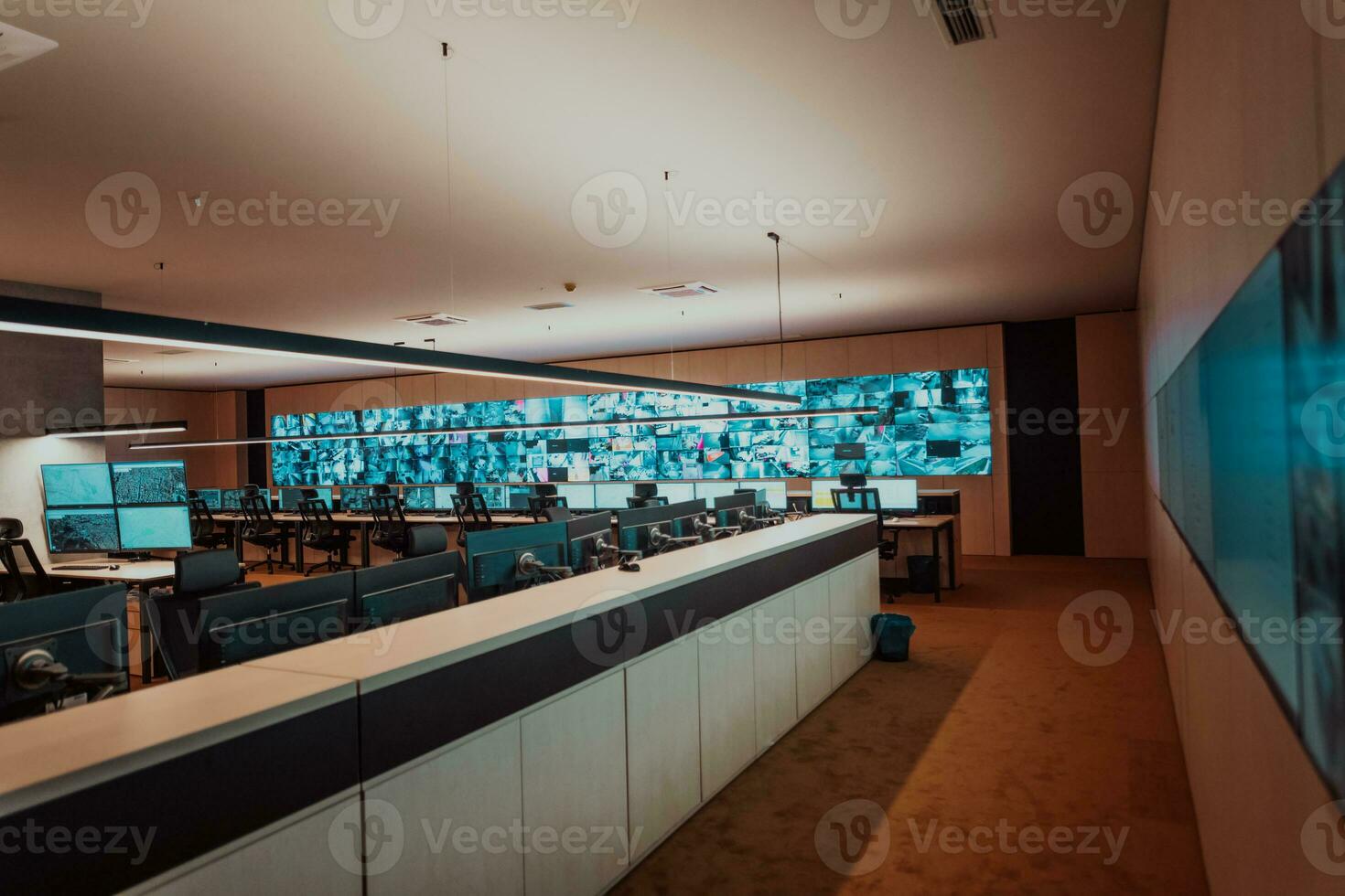 Empty interior of big modern security system control room, workstation with multiple displays, monitoring room with at security data center Empty office, desk, and chairs at a main CCTV security data photo