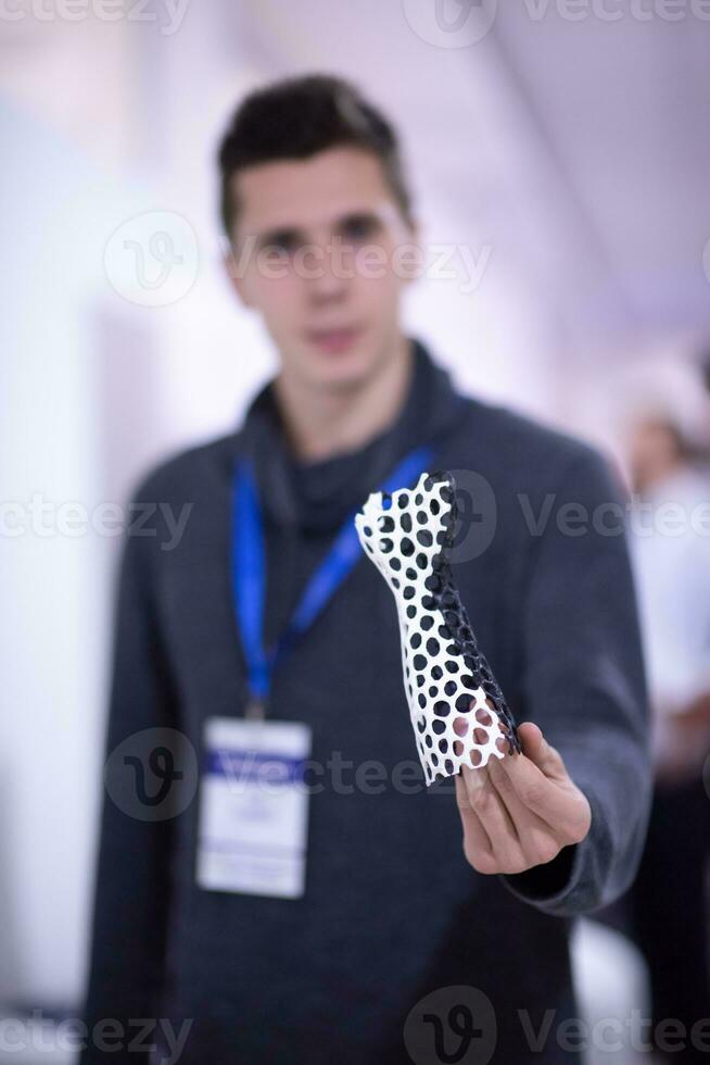 young engineer showing 3D printed model photo