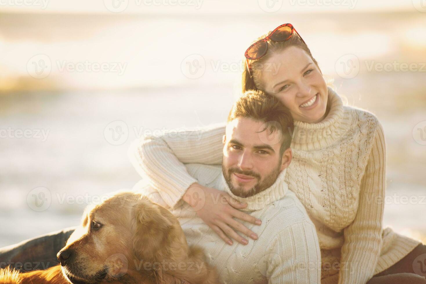 Couple with dog enjoying time on beach photo