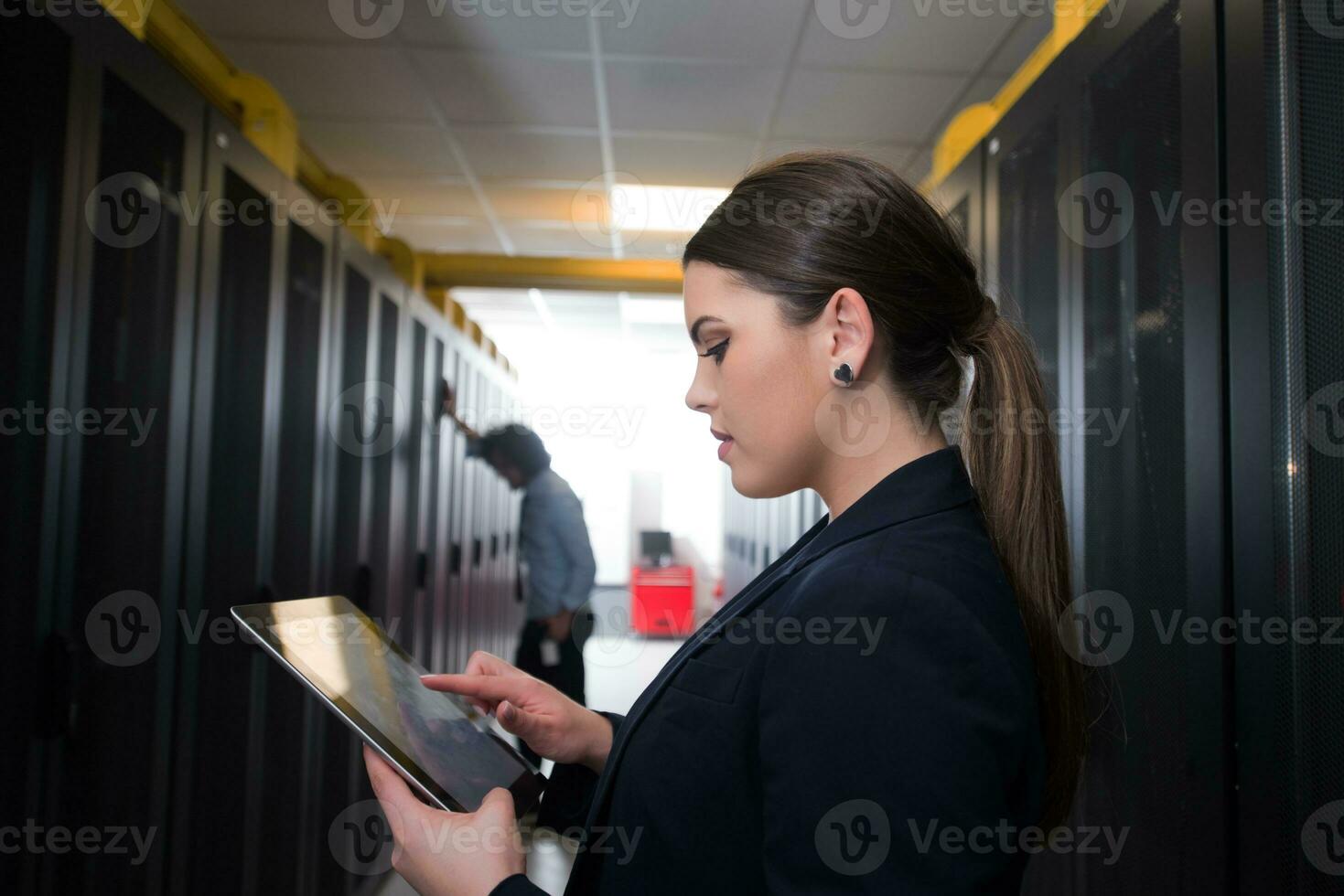 Female engineer working on a tablet computer in server room photo