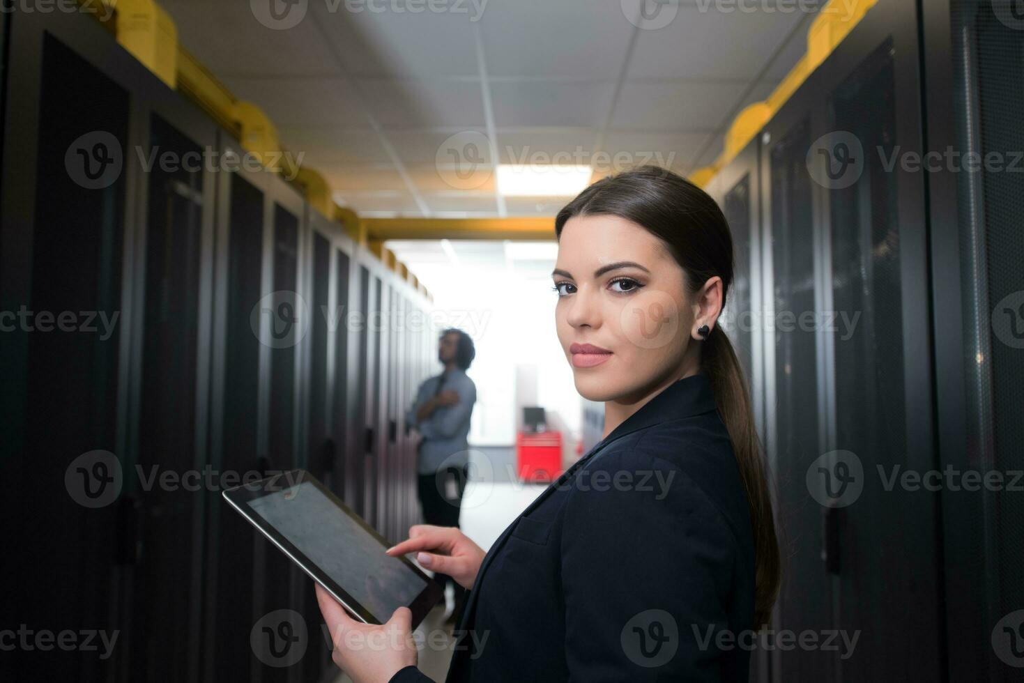 Female engineer working on a tablet computer in server room photo
