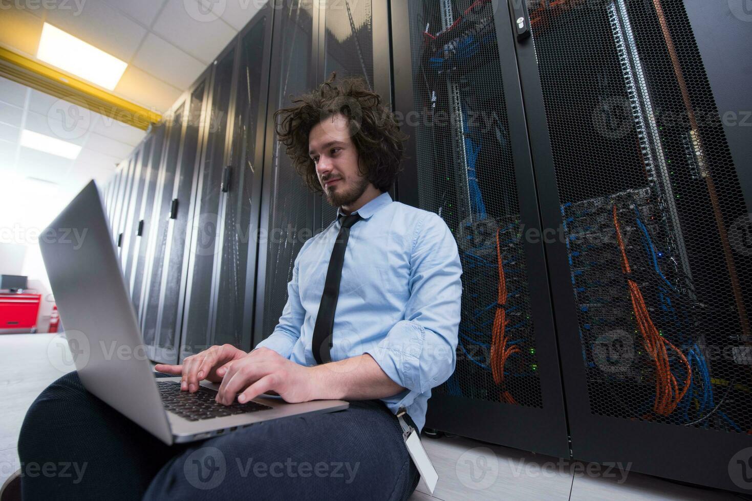 ingeniero que trabaja en una computadora portátil en la sala de servidores foto