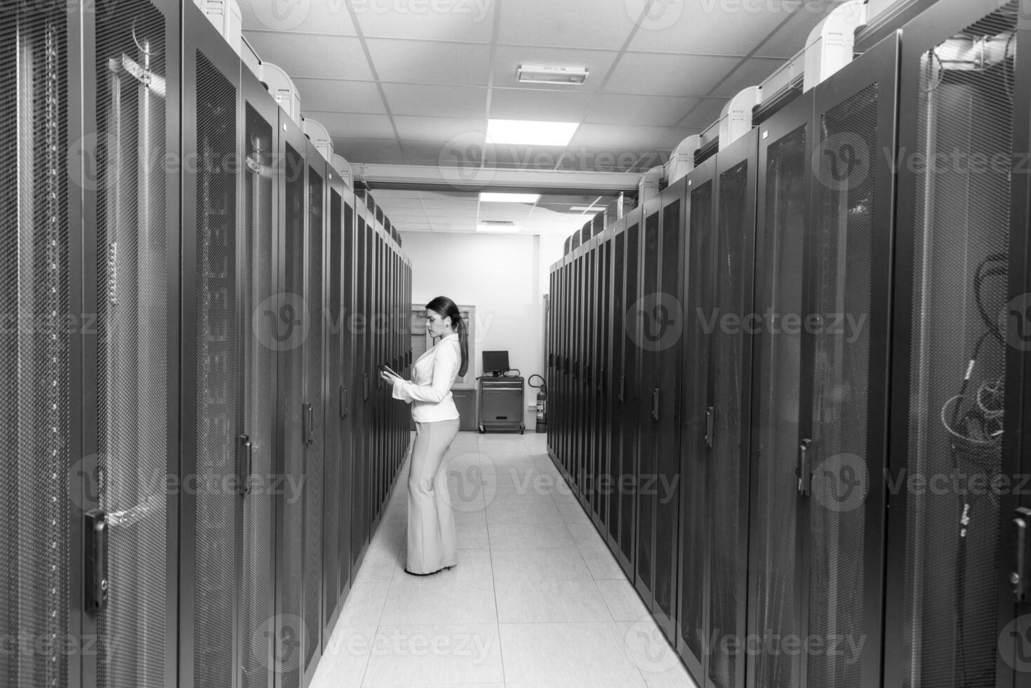 Female engineer working on a tablet computer in server room photo