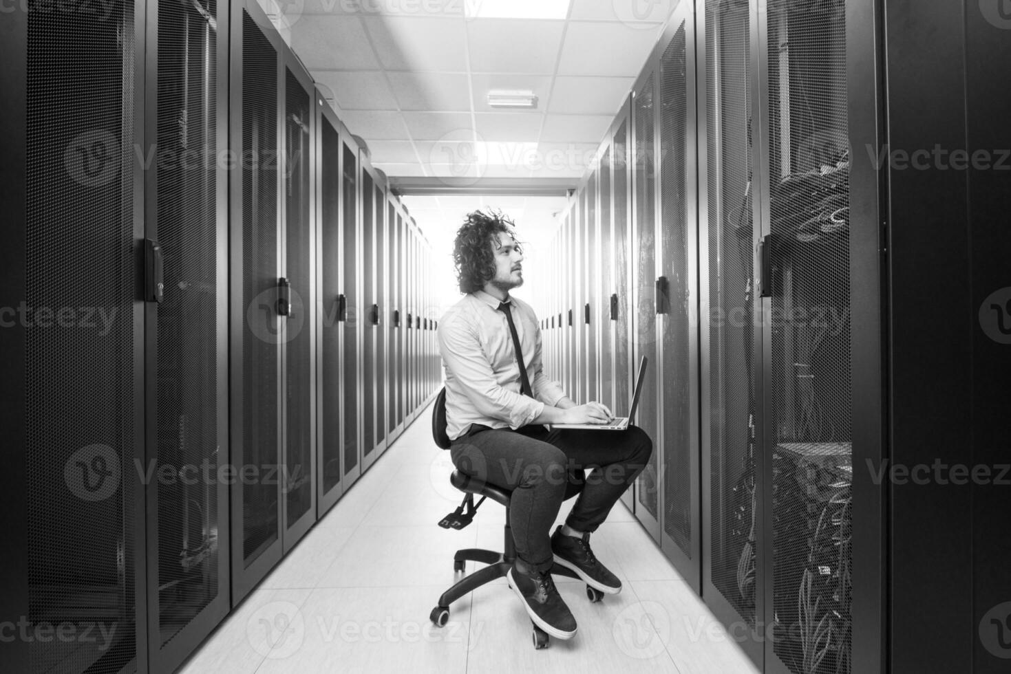 engineer working on a laptop in server room photo