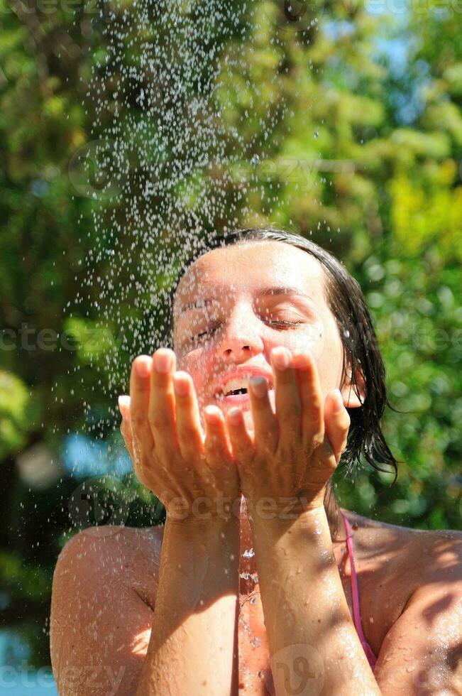 mujer bonita joven que se relaja bajo la ducha foto