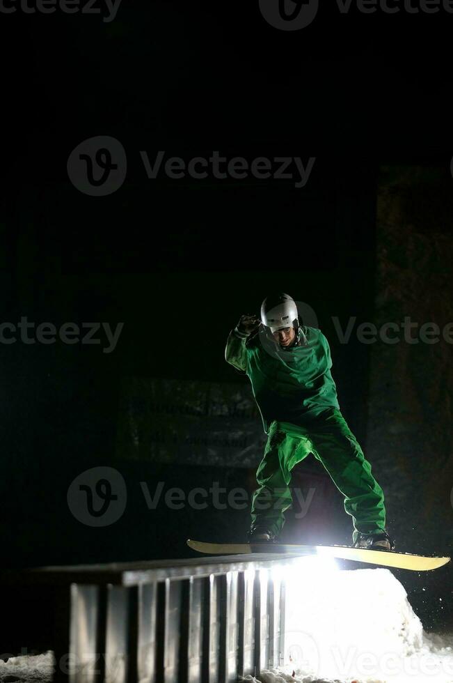 freestyle snowboarder jump in air at night photo