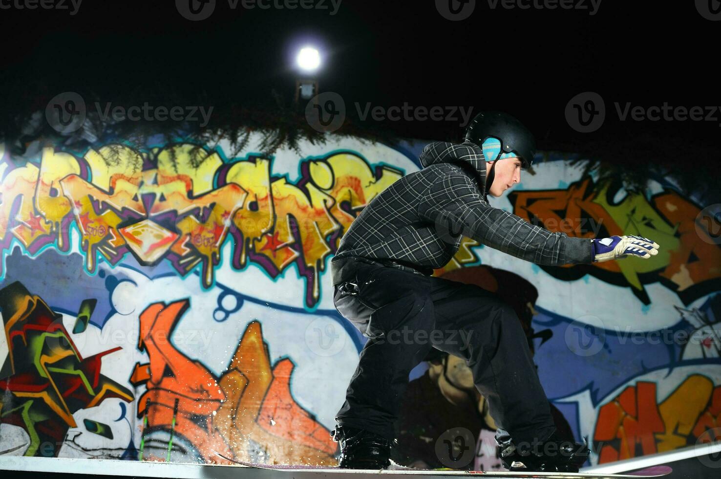 freestyle snowboarder jump in air at night photo