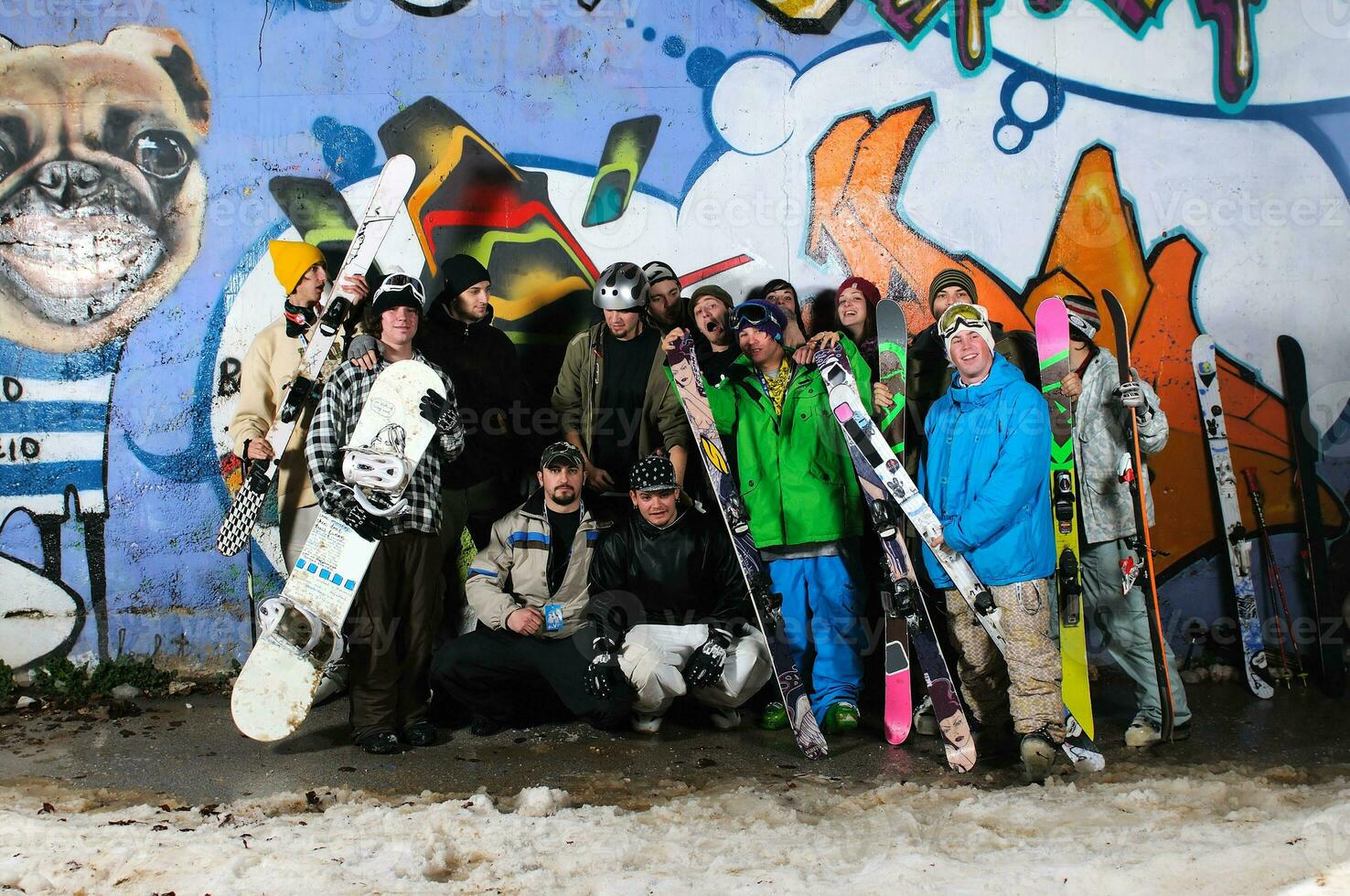 Group of  skiirs standing against background photo