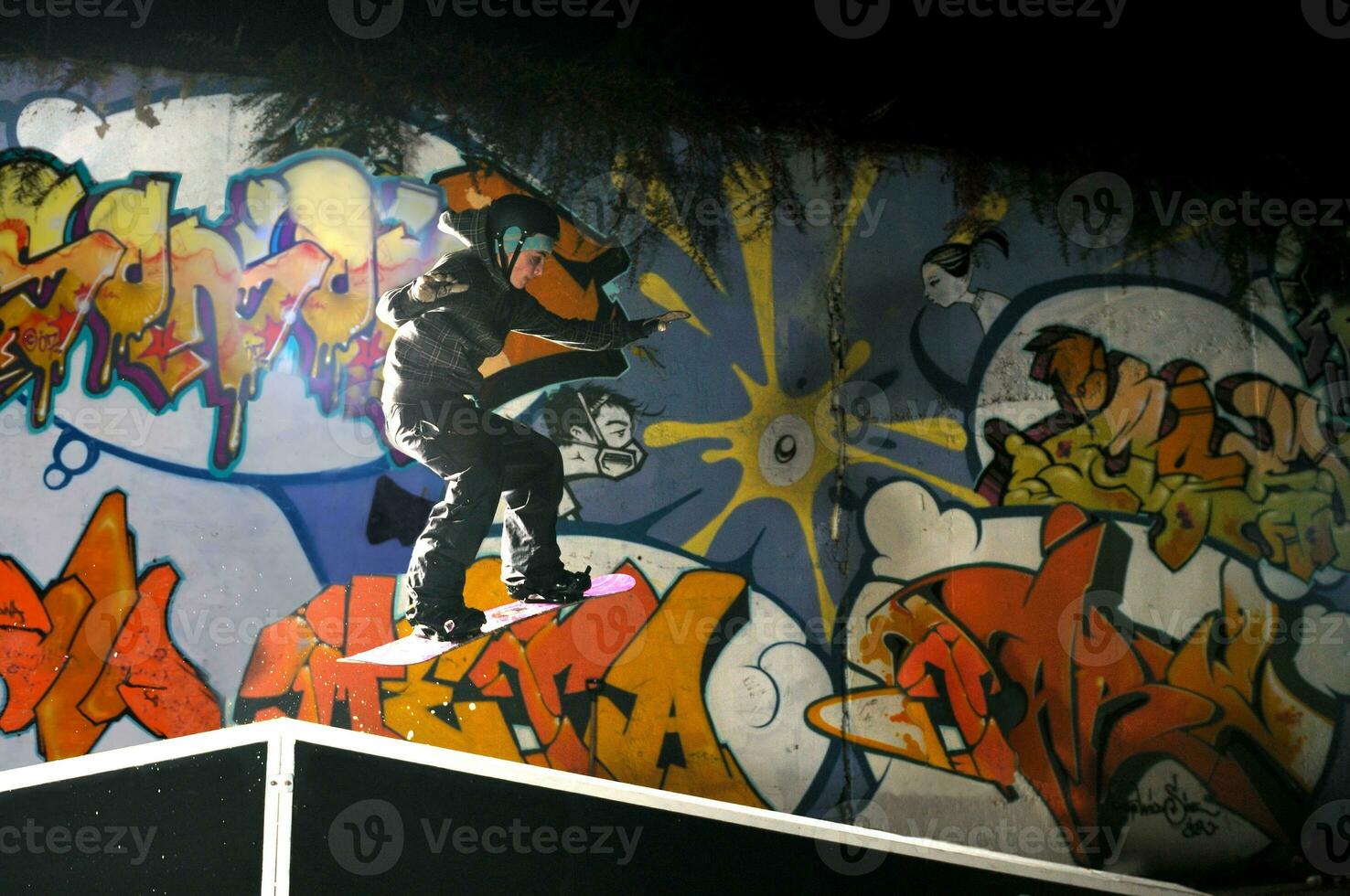 freestyle snowboarder jump in air at night photo