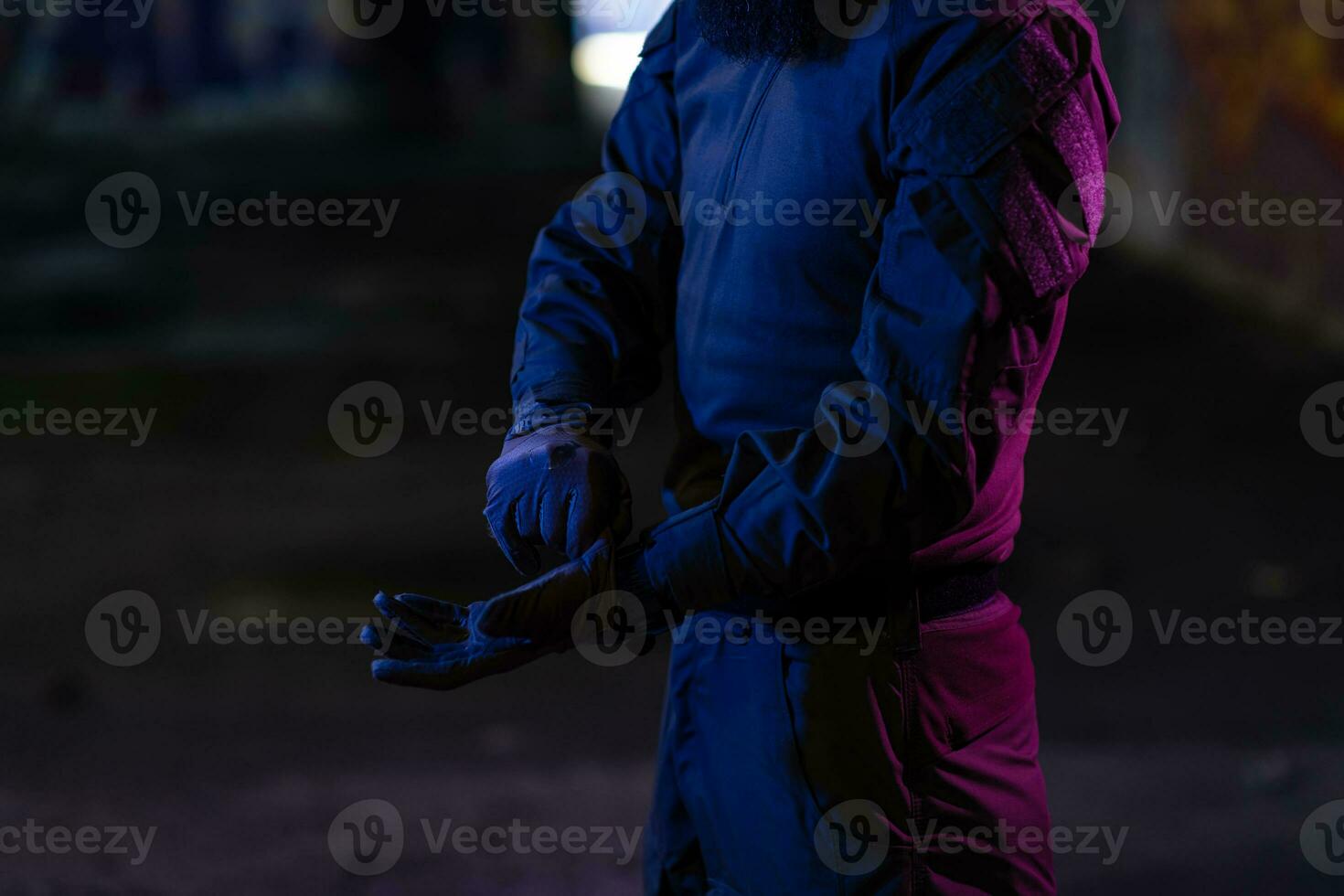 Modern warfare soldier checking navigation, time and other information on a smartwatch. Dark night black background. photo