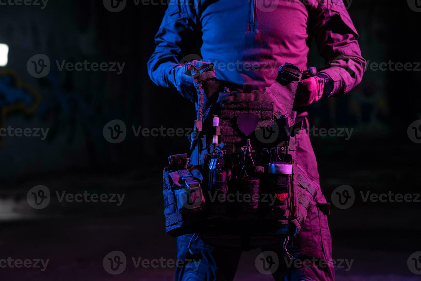 Army soldier in Combat Uniforms with an assault rifle and combat helmet night mission dark background. Blue and purple gel light effect. photo
