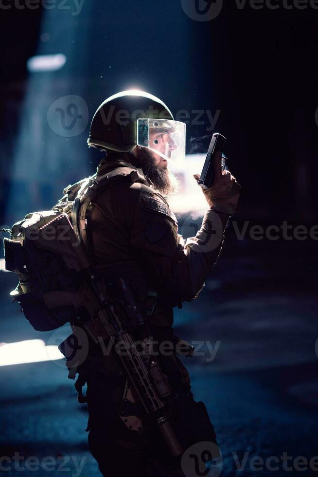 Ejército soldado en combate uniformes con un asalto rifle y combate casco noche misión oscuro antecedentes. azul y púrpura gel ligero efecto. foto