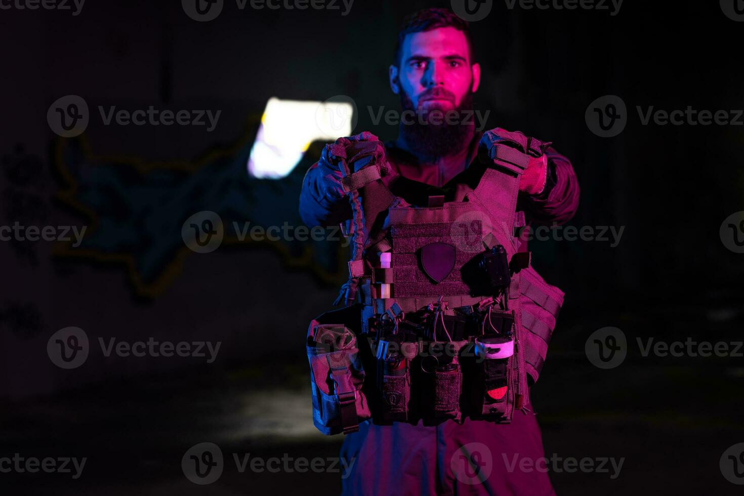 Army soldier in Combat Uniforms with an assault rifle and combat helmet night mission dark background. Blue and purple gel light effect. photo