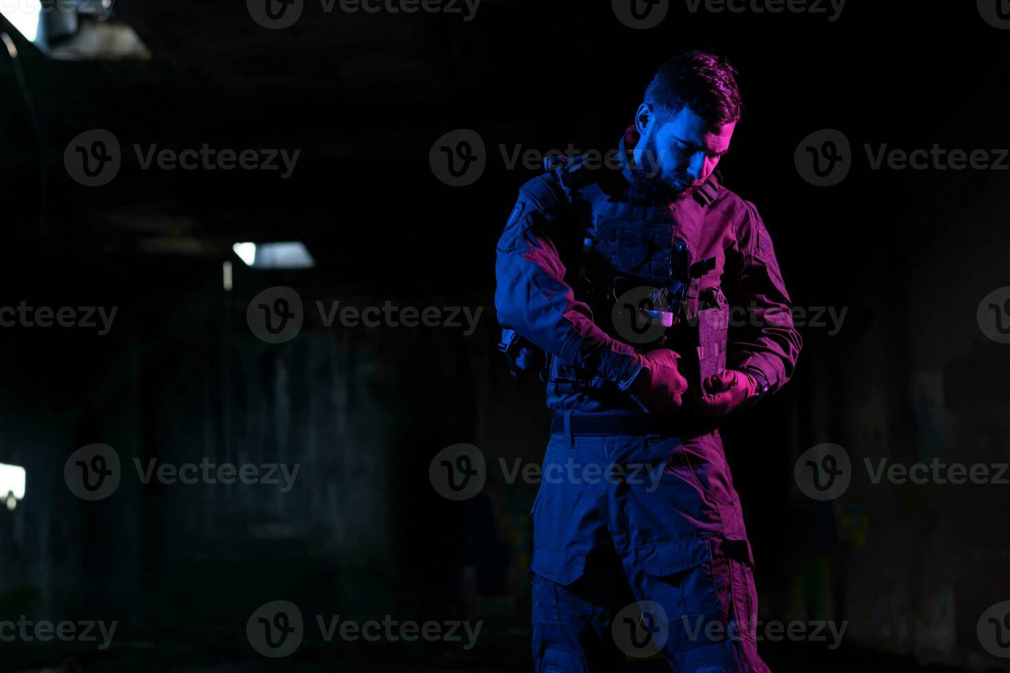 Army soldier in Combat Uniforms with an assault rifle and combat helmet night mission dark background. Blue and purple gel light effect. photo