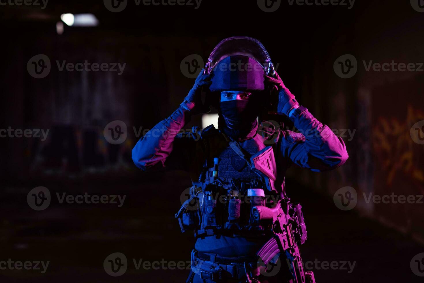 Ejército soldado en combate uniformes con un asalto rifle y combate casco noche misión oscuro antecedentes. azul y púrpura gel ligero efecto. foto