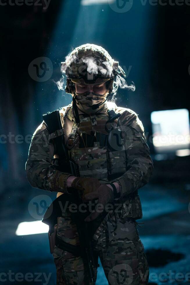 Army soldier in Combat Uniforms with an assault rifle and combat helmet night mission dark background. Blue and purple gel light effect. photo