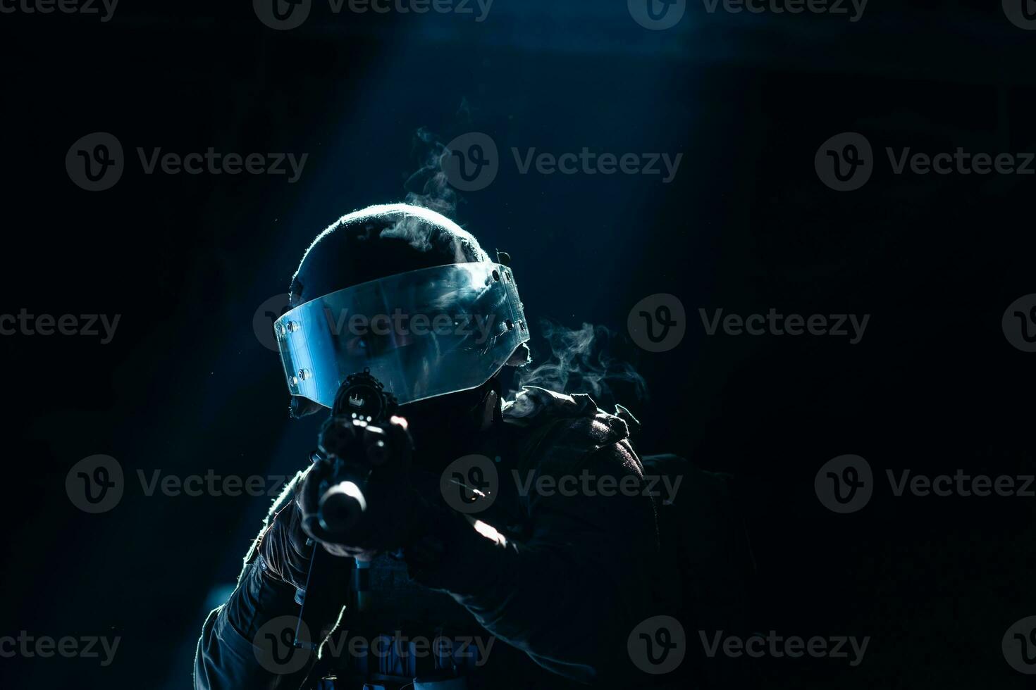 Army soldier in Combat Uniforms with an assault rifle and combat helmet night mission dark background. Blue and purple gel light effect. photo