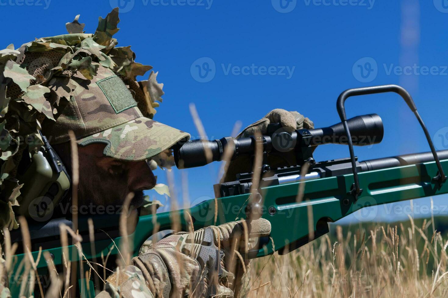 army soldier holding sniper rifle with scope and aiming in forest. war, army, technology and people concept photo