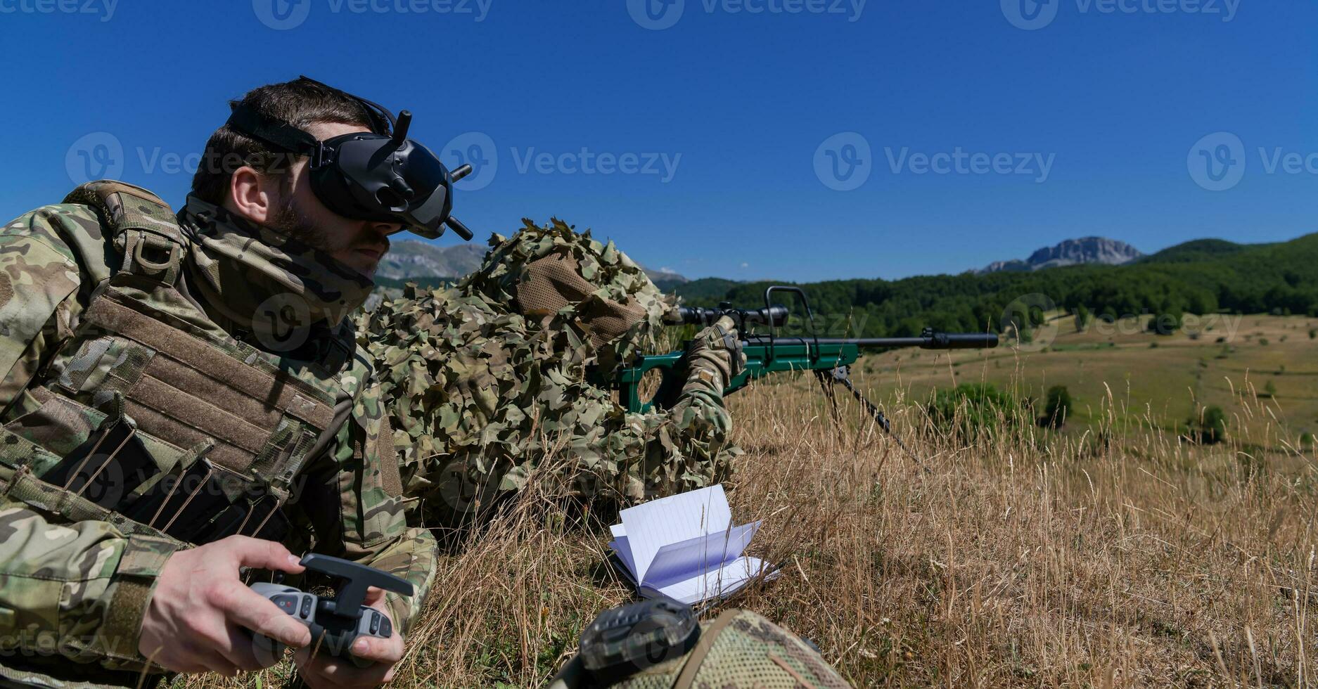 Sniper soldier assisted by an assistant to observe the area to be targeted with modern warfare tactical virtual reality goggles aerial drone military technology. photo