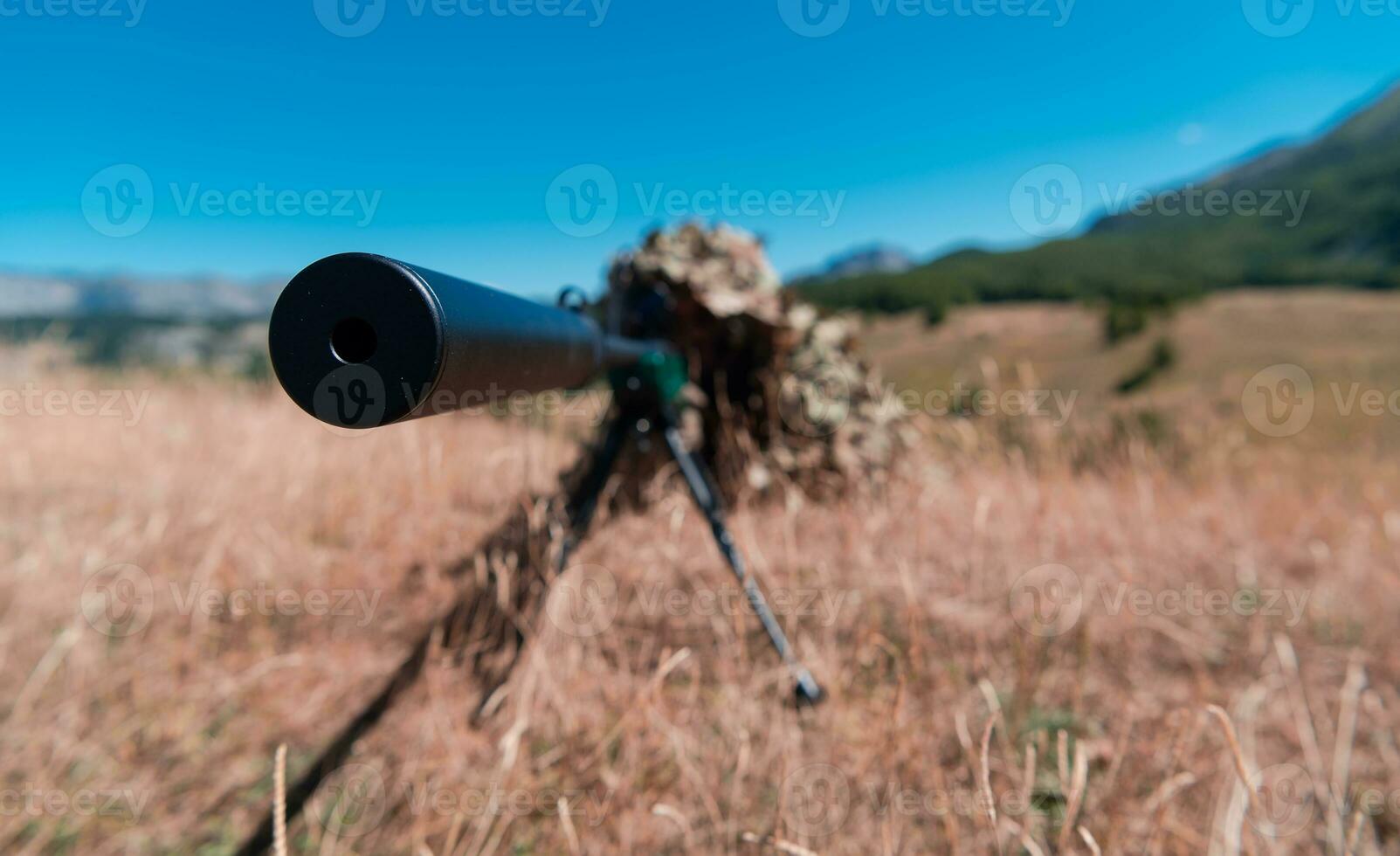 army soldier holding sniper rifle with scope and aiming in forest. war, army, technology and people concept photo