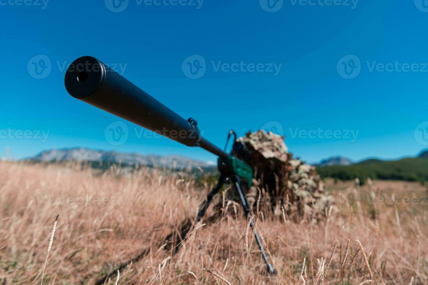 army soldier holding sniper rifle with scope and aiming in forest. war, army, technology and people concept photo