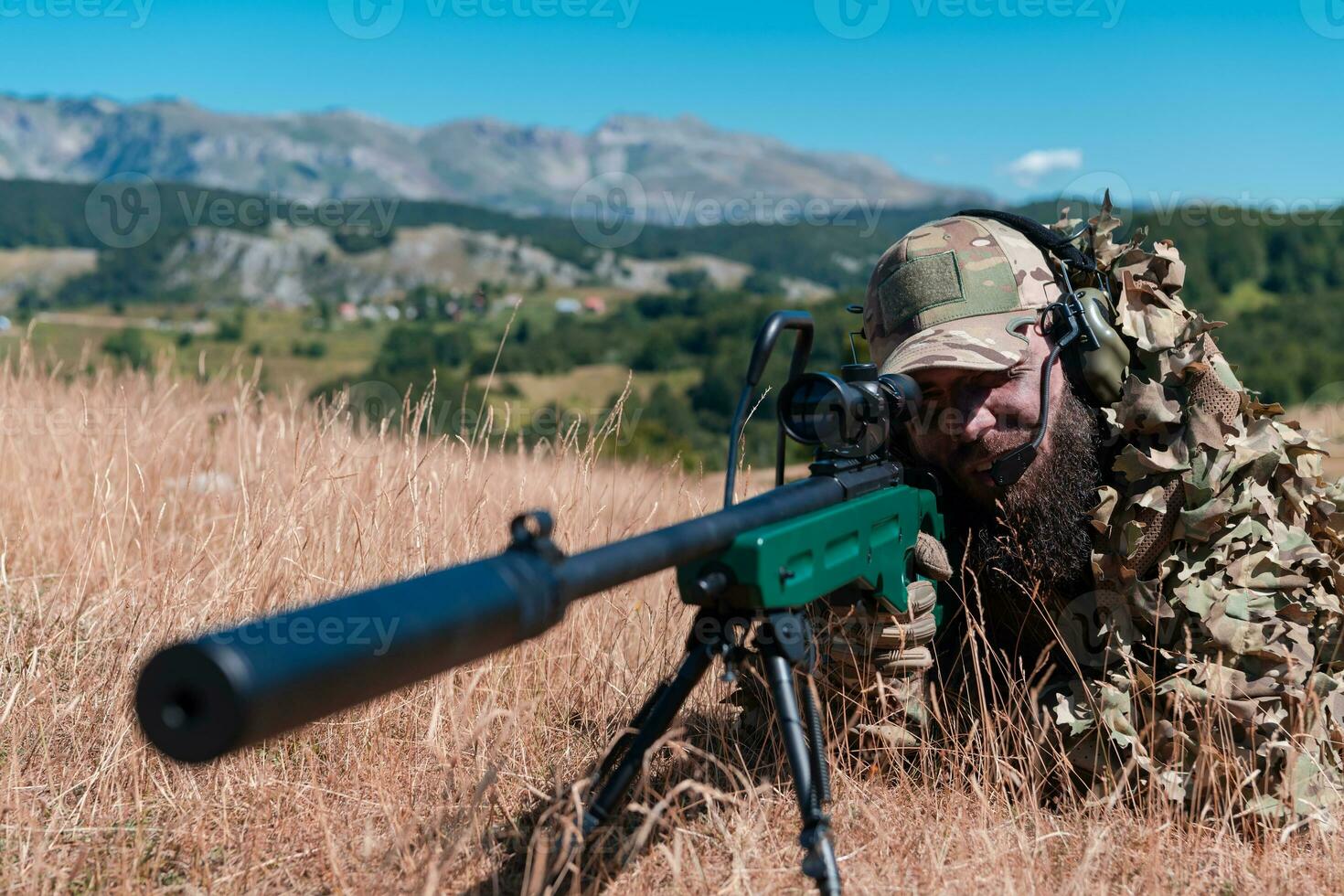 army soldier holding sniper rifle with scope and aiming in forest. war, army, technology and people concept photo