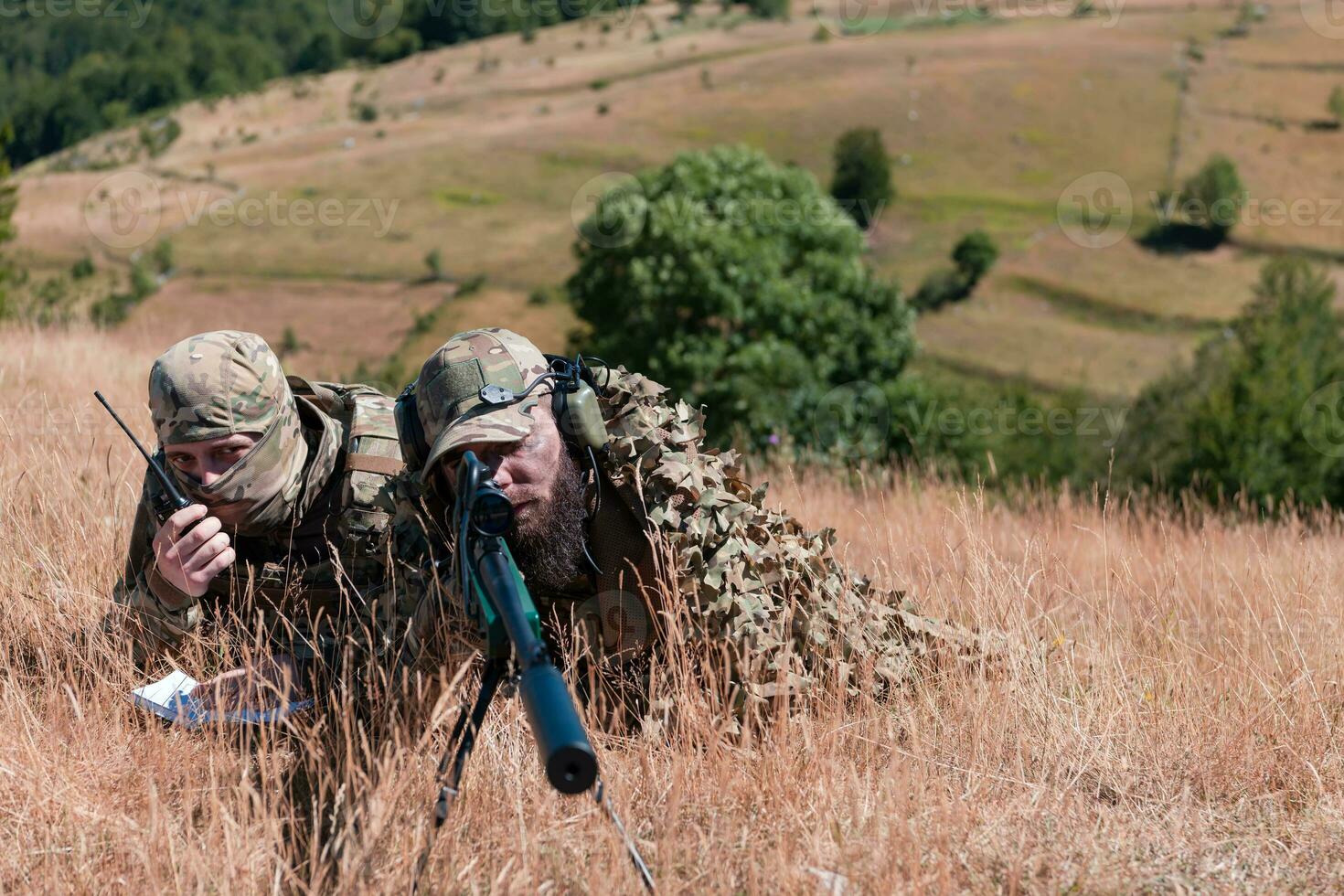 Sniper soldier assisted by an assistant to observe the area to be targeted with modern warfare tactical virtual reality goggles aerial drone military technology. photo
