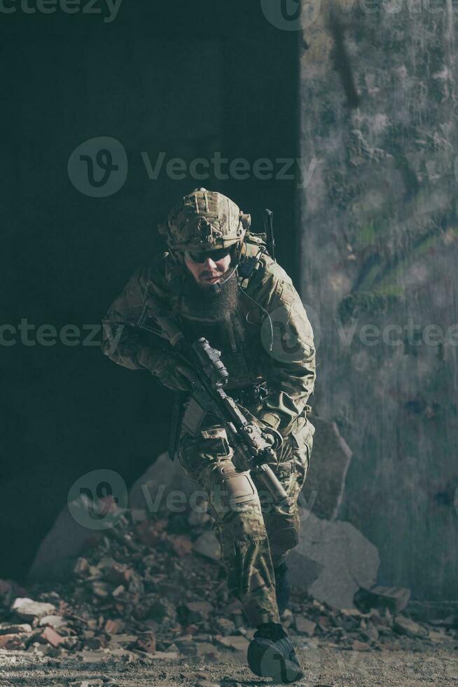 A bearded soldier in uniform of special forces in a dangerous military action in a dangerous enemy area. Selective focus photo