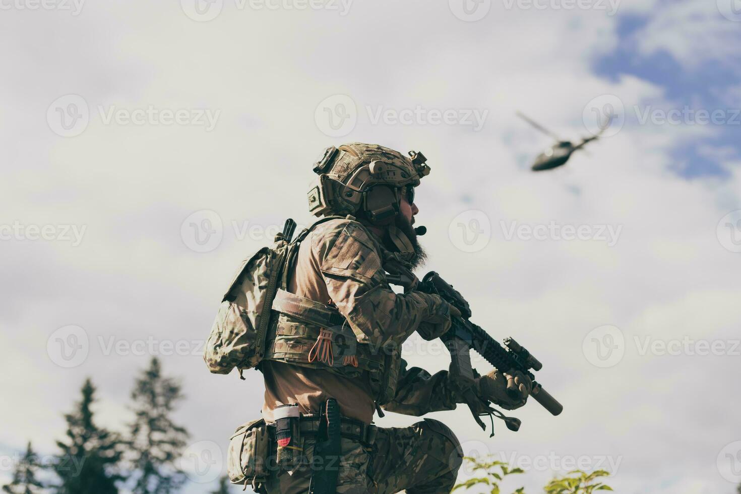 War concept. A bearded soldier in a special forces uniform fighting an enemy in a forest area. Selective focus photo