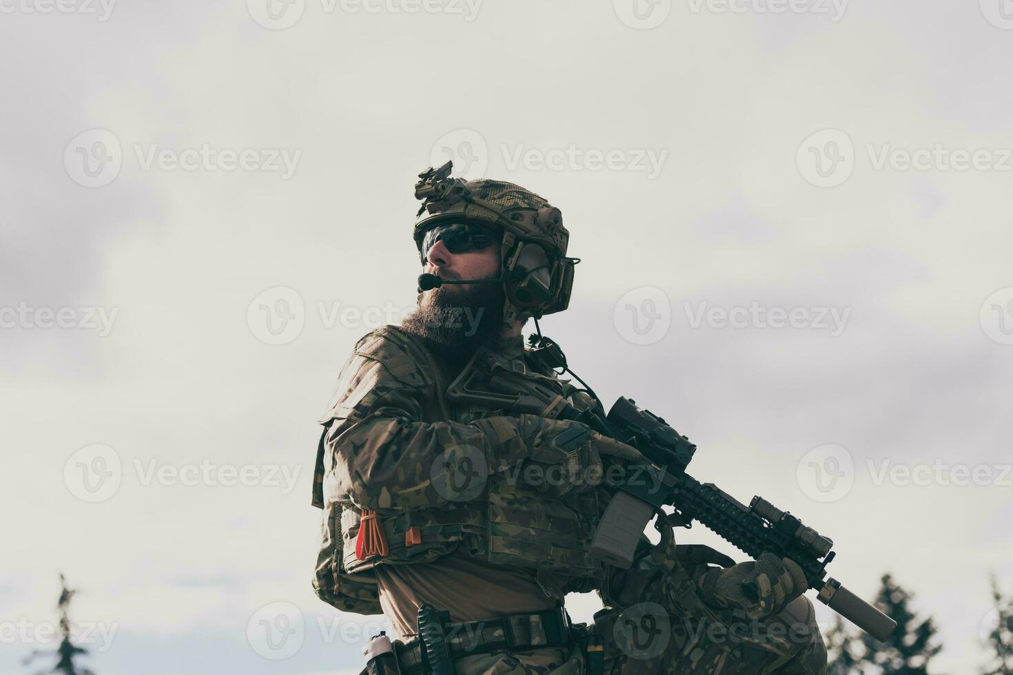 War concept. A bearded soldier in a special forces uniform fighting an enemy in a forest area. Selective focus photo