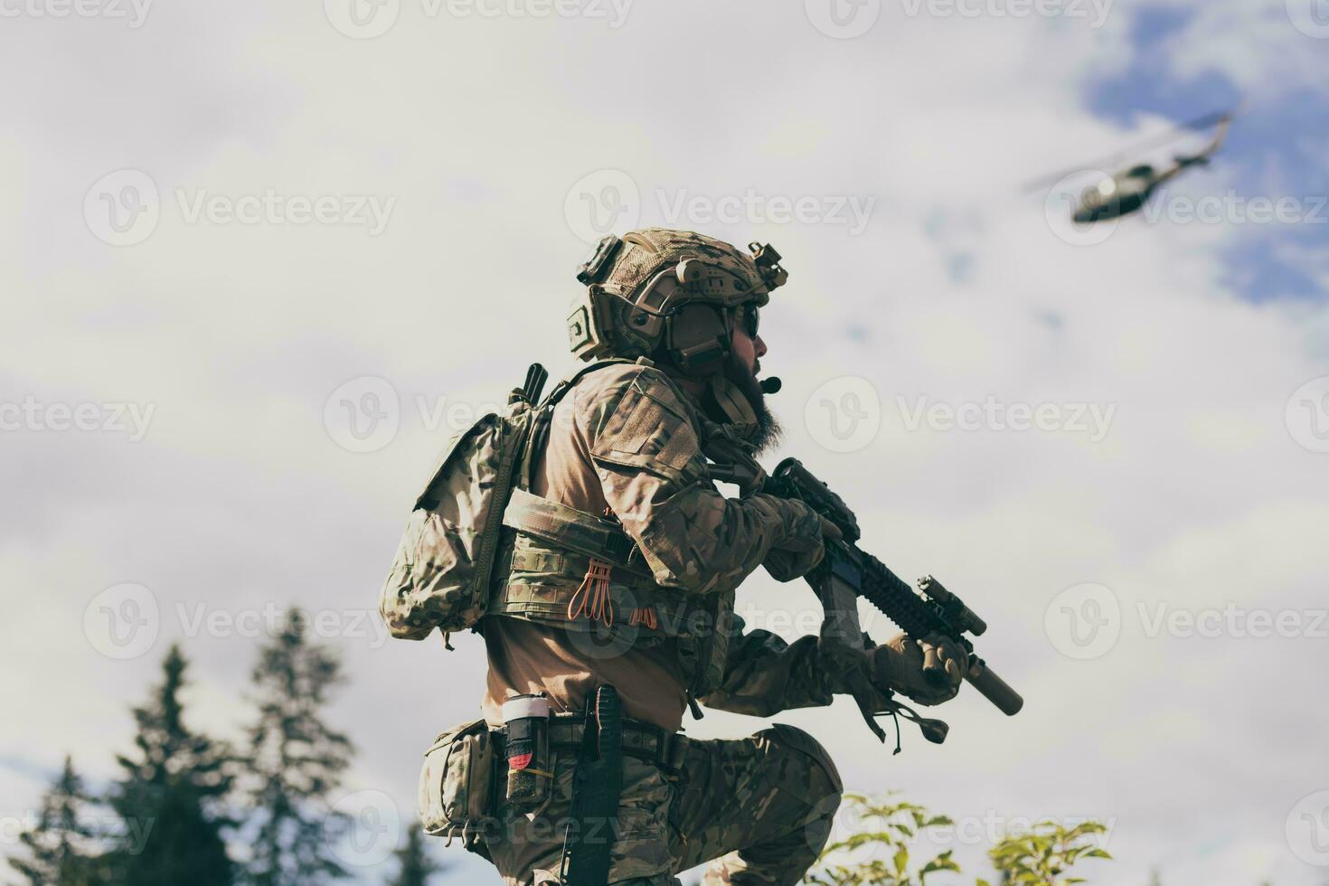 War concept. A bearded soldier in a special forces uniform fighting an enemy in a forest area. Selective focus photo