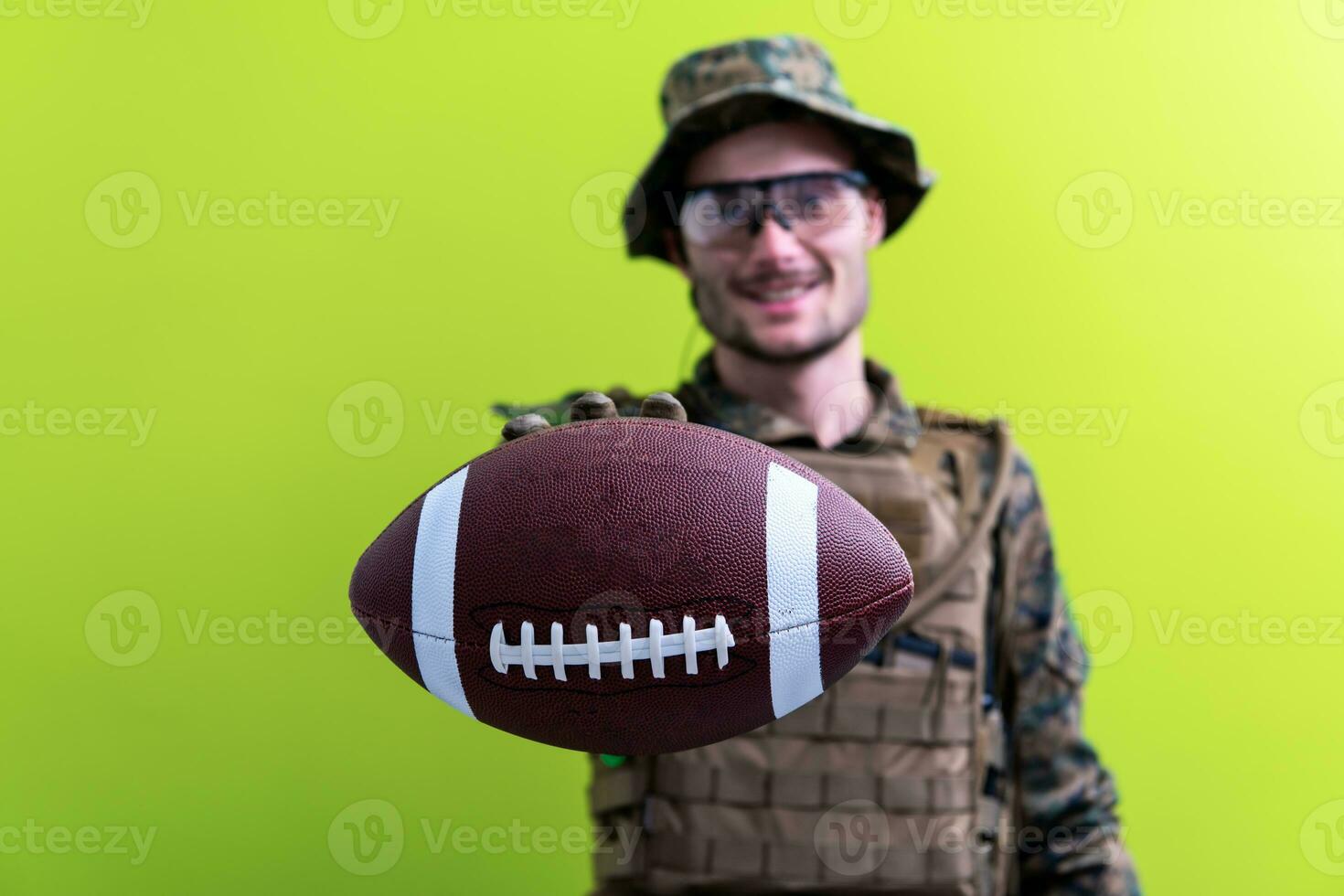 soldadura sosteniendo una pelota de fútbol americano foto